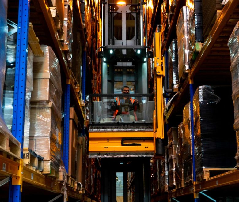 Un chariot élévateur au milieu des racks de stockage de produits électroniques, pièces détachés et composants